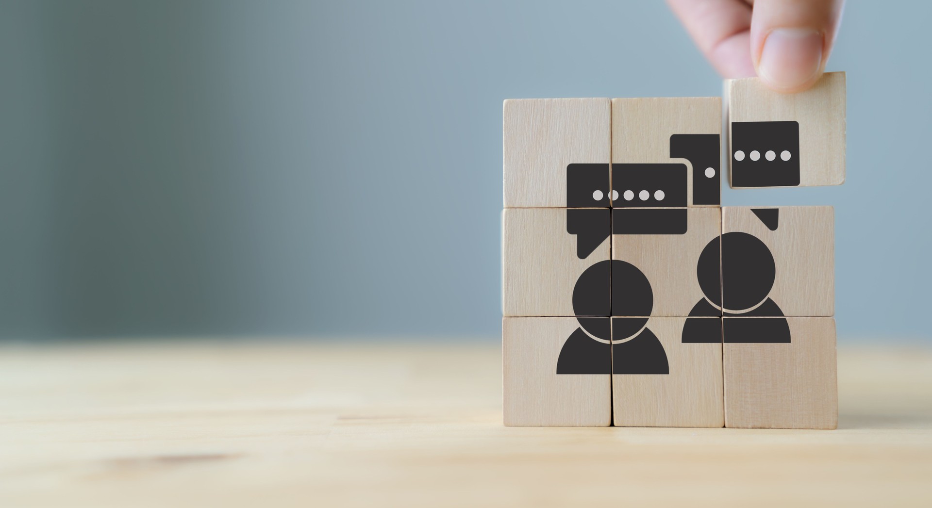 Concept de rétroaction des consommateurs.  Évaluation de la satisfaction client pour améliorer et développer le produit et le service. Centré sur le client. La main met des cubes en bois avec l’icône « feedback » sur fond gris, espace de copie.